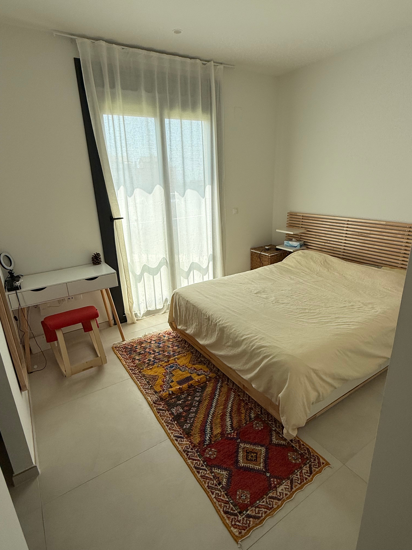 Spacious master bedroom with wooden headboard and terrace access in modern Tarifa townhouse